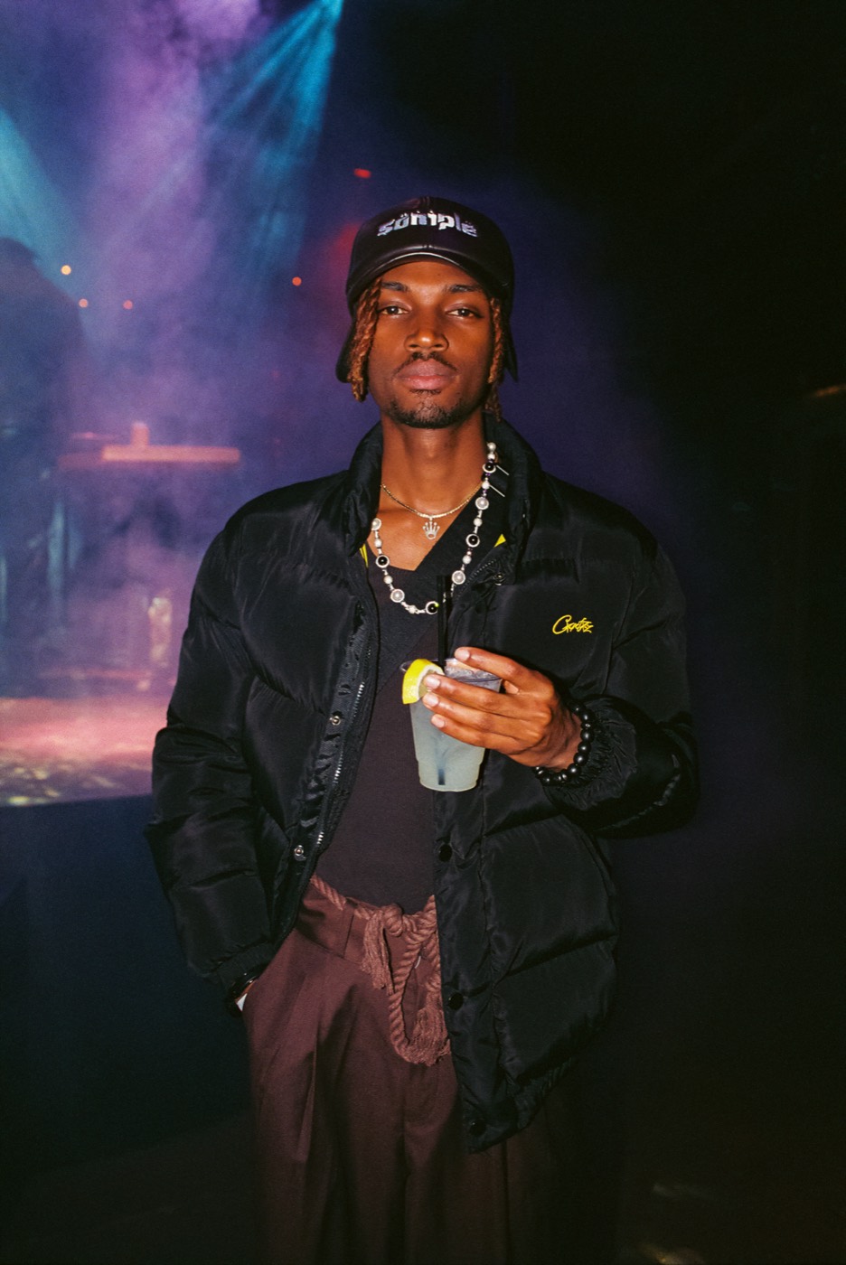 A guest with a cocktail in front of the stage lights